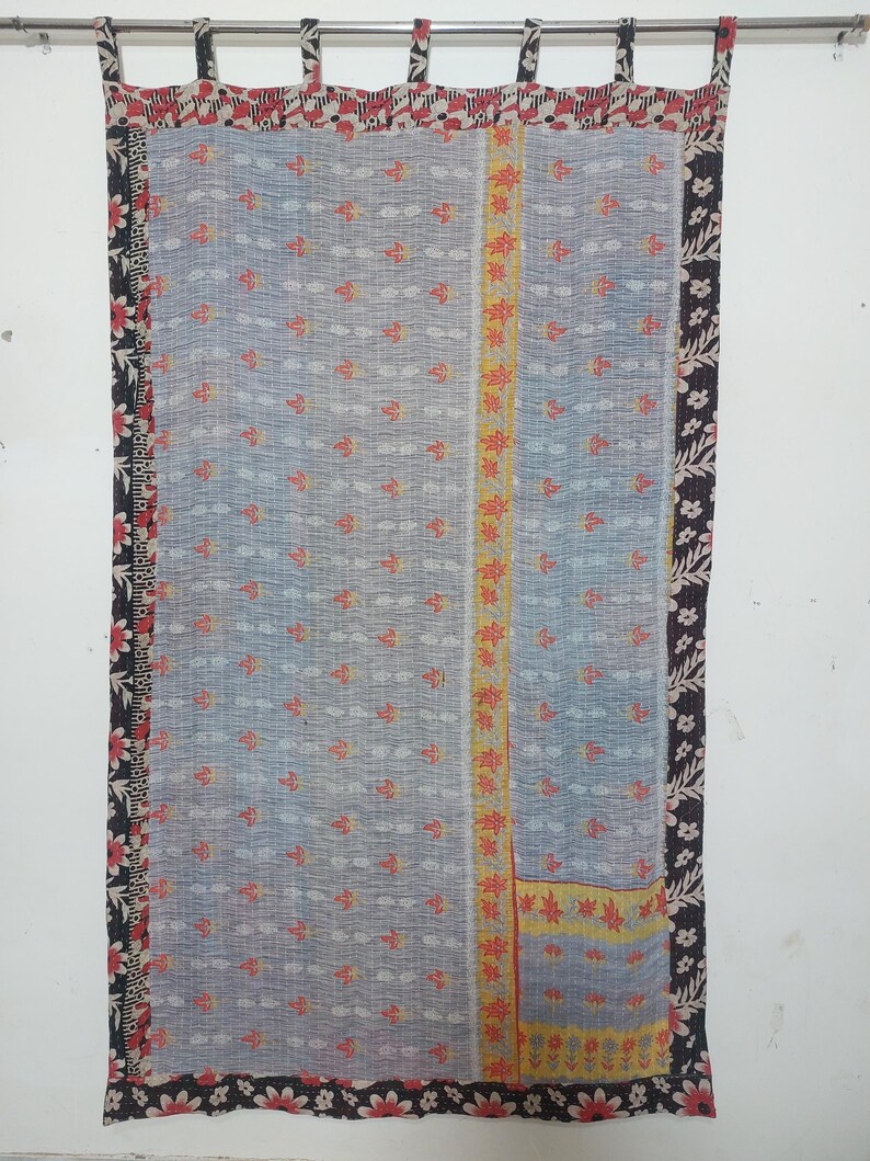 Puede incluir: Cortina azul claro con un estampado floral y un borde decorativo. La cortina tiene una franja vertical central con dise&ntilde;os florales amarillos y rojos. El borde superior tiene lazos para colgar.