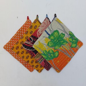 Puede incluir: Un conjunto de cinco agarraderas acolchadas y coloridas. Cada una de forma cuadrada presenta un patrón único, incluyendo diseños de cachemira, florales y abstractos en tonos naranja, amarillo, rojo y verde. Cuentan con un lazo para colgar.