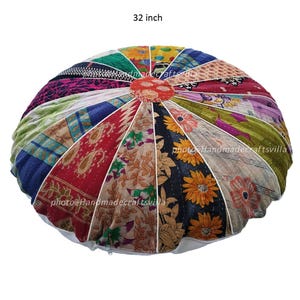 Puede incluir: Un cojín de suelo redondo de patchwork multicolor con un borde blanco y una cremallera. El cojín está hecho de una variedad de telas, incluyendo estampados florales, patrones de cachemira y colores sólidos. El cojín tiene un diámetro de 81 cm.