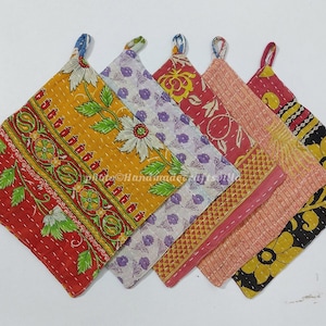 Puede incluir: Conjunto de cinco agarraderas de olla de algodón acolchado de colores vivos con patrones florales. Cada agarradera tiene un asa de bucle.