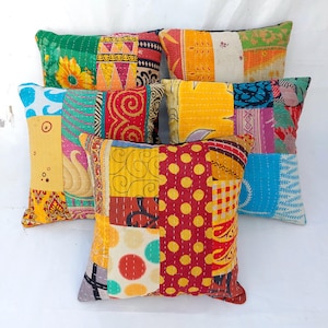 May include: Five colourful patchwork cushion covers with a variety of patterns and colours, including blue, green, yellow, red, and orange. The cushions are made from recycled saris and are perfect for adding a touch of bohemian style to any room.