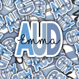 May include: A blue and white sticker with the text "AUD Emma" in black cursive writing.