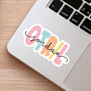 May include: A colorful sticker with the word "OTRIL" in rainbow colors and the word "jordan" written in black cursive underneath.