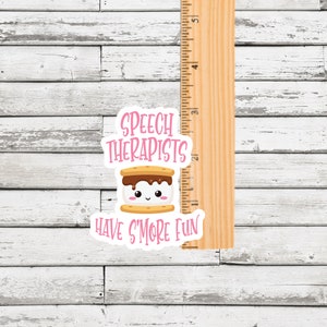 May include: A pink and white sticker with a cartoon s'more and the text "Speech Therapists Have S'more Fun".