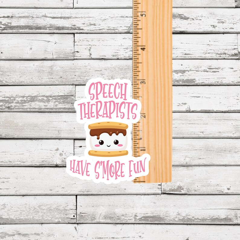 May include: A pink and white sticker with a cartoon s'more and the text "Speech Therapists Have S'more Fun".