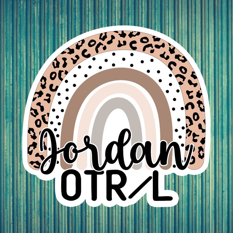 May include: A rainbow sticker with a leopard print border. The rainbow is in shades of brown, beige, and white. The text "Jordan OTR/L" is written in black cursive font below the rainbow.