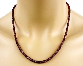 Op de afbeelding: Een ketting gemaakt van kleine, donkerrode granaat kralen. De ketting is om de nek van een mannequin.