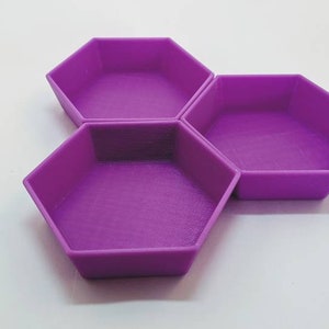 May include: Three purple hexagonal shaped dishes, arranged in a honeycomb pattern.