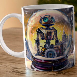 May include: A white ceramic mug with a colorful image of a robot inside a snow globe. The robot has a large, single eye and is standing in a snowy scene.