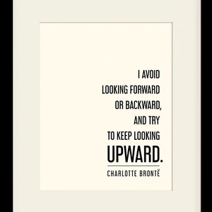 May include: A black framed print with a white background and black text that reads "I avoid looking forward or backward, and try to keep looking upward. Charlotte Brontë". The frame is 28 cm by 36 cm with a 20 cm by 25 cm mat opening.