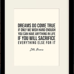 Puede incluir: Impresión tipográfica en blanco y negro con una cita de J.M. Barrie: "Los sueños se hacen realidad si solo deseamos con suficiente fuerza. Puedes tener cualquier cosa en la vida si estás dispuesto a sacrificar todo lo demás por ella." La impresión está enmarcada en un marco negro y se muestra contra una pared de azulejos rosas.
