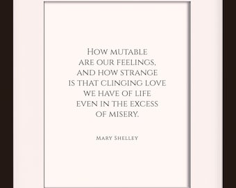 May include: A black framed print with a white background and a quote by Mary Shelley that reads "How mutable are our feelings, and how strange is that clinging love we have of life even in the excess of misery." The print is framed in a 11 x 14 frame with an 8 x 10 mat opening.