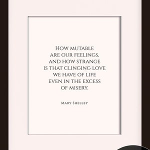 May include: A black framed print with a white background and a quote by Mary Shelley that reads "How mutable are our feelings, and how strange is that clinging love we have of life even in the excess of misery." The print is framed in a 11 x 14 frame with an 8 x 10 mat opening.