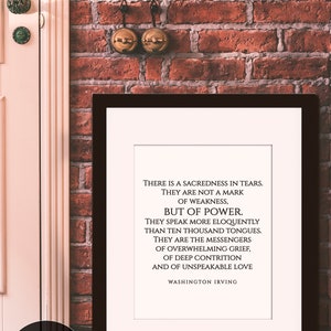 May include: A black framed print with a white background and black text. The text reads: "There is a sacredness in tears. They are not a mark of weakness, but of power. They speak more eloquently than ten thousand tongues. They are the messengers of overwhelming grief, of deep contrition and of unspeakable love. Washington Irving."