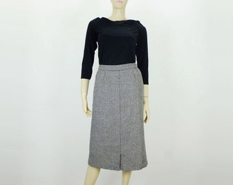 May include: A black and white houndstooth skirt with a straight silhouette. The skirt is knee-length and has a front slit.