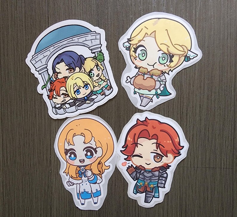 Puede incluir: Cuatro pegatinas de dibujos animados con personajes de estilo anime. Una muestra un grupo bajo un arco. Las otras tres representan personajes individuales con cabello rubio, naranja y rojo, cada uno con atuendos y expresiones &uacute;nicos. Las pegatinas est&aacute;n sobre una superficie gris.