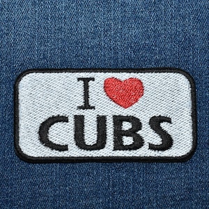 May include: White patch with black stitching and the text "I love CUBS" with a red heart in between the words "I" and "CUBS".