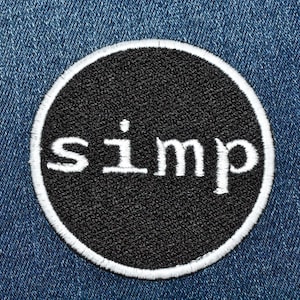May include: A black and white embroidered patch with the word "simp" in white lettering on a black circle.