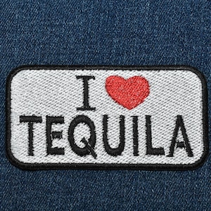 May include: Embroidered patch with the phrase "I ❤️ TEQUILA" in black letters and a red heart on a white background. The patch is rectangular with a black border and is set against a blue denim background.
