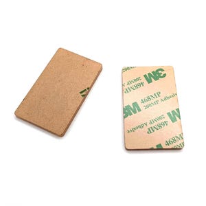 May include: Two rectangular adhesive pads. One is plain brown, the other has the 3M logo and text: "468MP 200MP Adhesive". The pads are on a white background.