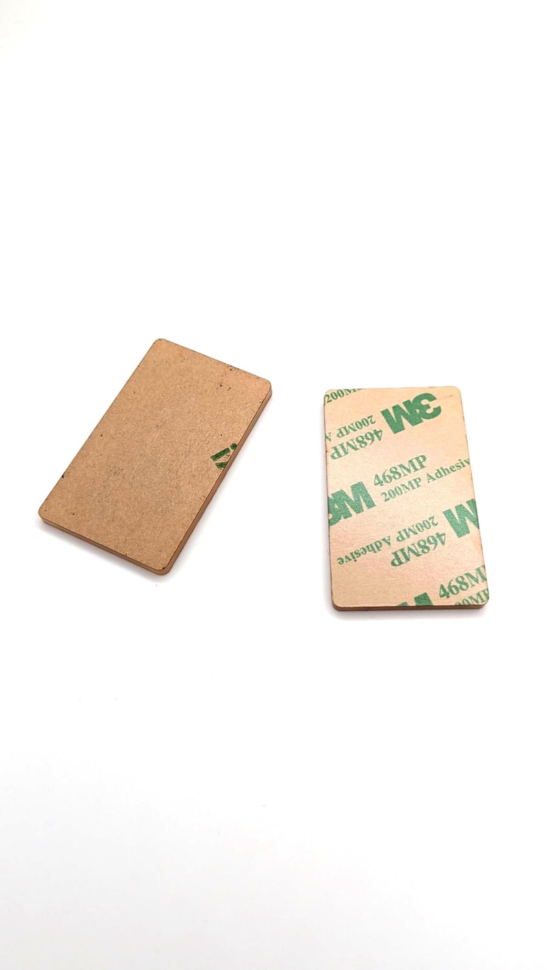 May include: Two rectangular adhesive pads. One is plain brown, the other has the 3M logo and text: "468MP 200MP Adhesive". The pads are on a white background.