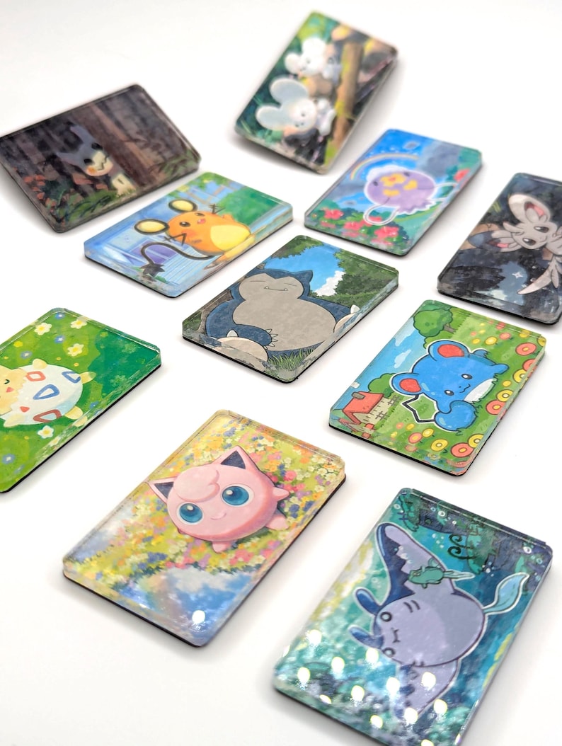 May include: A collection of rectangular, illustrated magnets featuring various cartoon characters. The magnets showcase vibrant colors and detailed artwork, with a white background. The characters are set against scenic backgrounds.