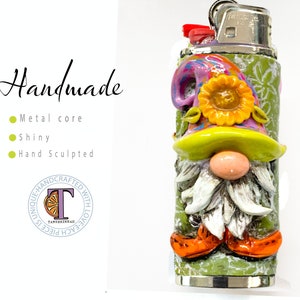 May include: A hand-sculpted gnome lighter with a green base, a white beard, and a purple, yellow, and green hat with a yellow flower. The lighter is made of metal and is shiny.