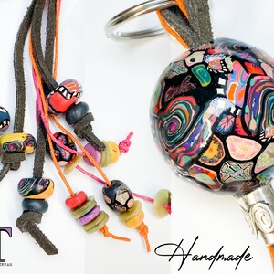 May include: A colorful, handmade key chain with a black and white patterned sphere, a silver ring, and multiple strands of leather and colorful beads.