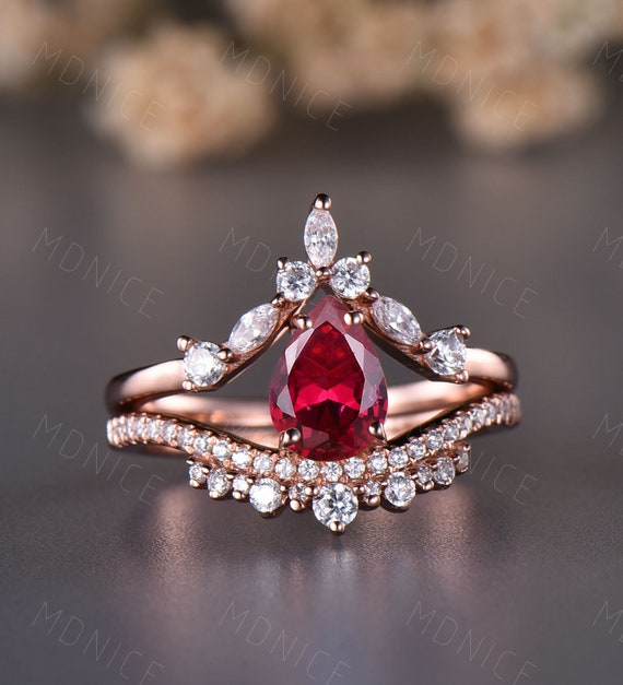 Hand Holding Pear Cut Ruby Ring 18K Yellow Gold