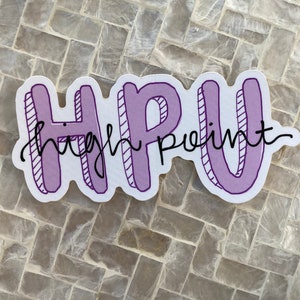 K&ouml;nnte beinhalten: Ein wei&szlig;er Aufkleber mit dem Text "HPU High Point" in Lila und Schwarz. Die Buchstaben "HPU" sind fett umrandet, mit den Worten "High Point" in einer kursiven Schrift darunter.