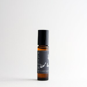 May include: A black roller bottle with a label that says "FLIGHT" and "CLARY SAGE". The label also features a stylised image of a bird in flight.