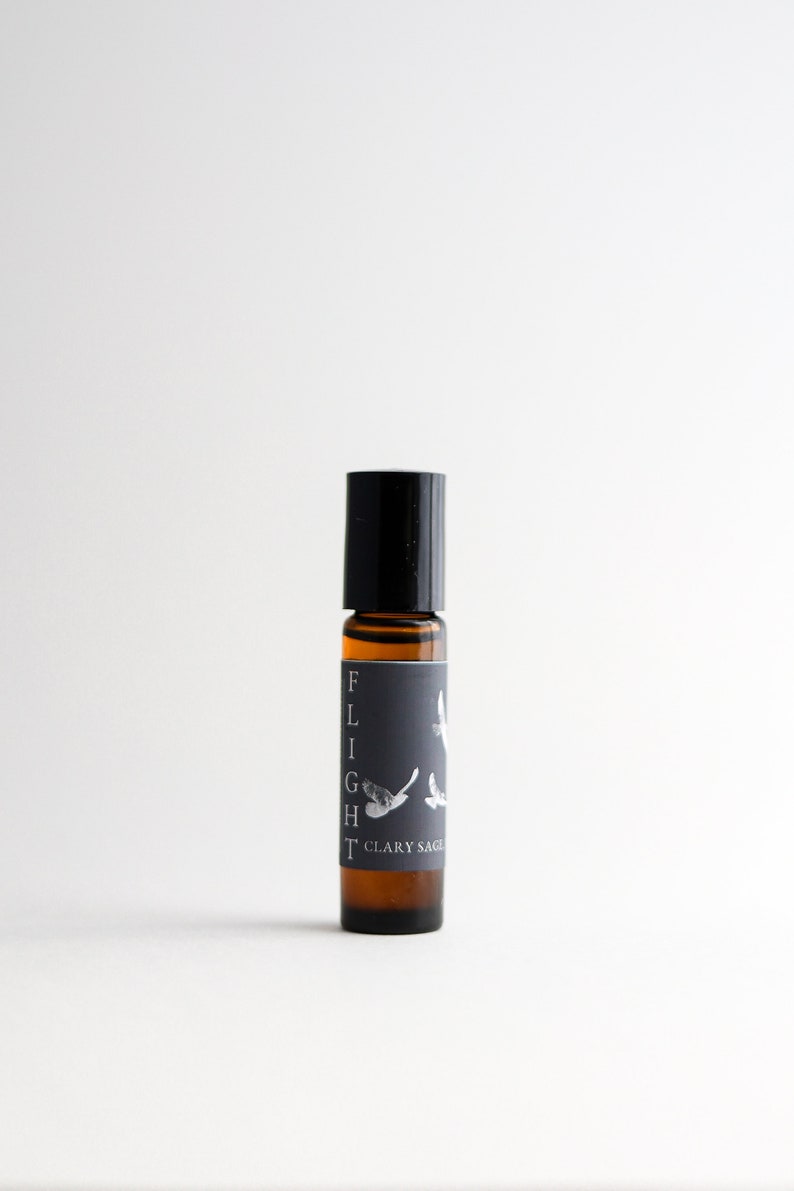 May include: A black roller bottle with a label that says "FLIGHT" and "CLARY SAGE". The label also features a stylised image of a bird in flight.