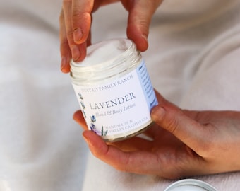 May include: A white jar of lavender hand and body lotion with a white label that reads "NUSTAD FAMILY RANCH LAVENDER Hand & Body Lotion HANDMADE IN VALLEY CALIFORNIA"
