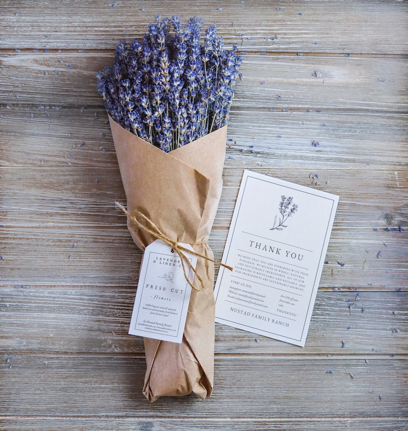 May include: A bouquet of purple lavender flowers wrapped in brown paper with a thank you note and a tag that reads "Lavender & Linen Co. Fresh Cut Flowers".