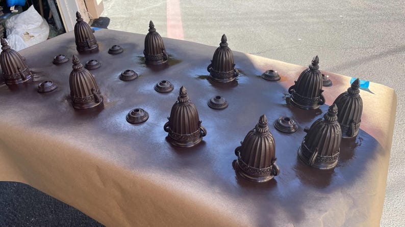 Peut inclure: Une collection de 10 embouts en m&eacute;tal brun fonc&eacute; en forme de d&ocirc;me, dispos&eacute;s sur une surface de papier brun. Les embouts sont tous de la m&ecirc;me taille et de la m&ecirc;me forme, et ils ont une finition l&eacute;g&egrave;rement textur&eacute;e.