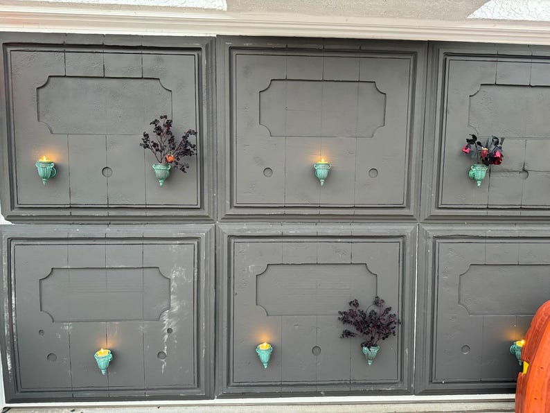 Peut inclure: Un mur gris avec six panneaux rectangulaires, chacun avec un cadre d&eacute;coratif. Chaque panneau a une petite plante en pot et un bougeoir allum&eacute;.