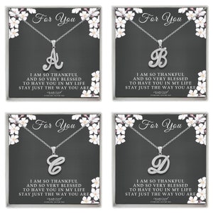 May include: Four silver necklace boxes with white floral designs. Each box features a different letter charm, A, B, C, and D, with the text "For You" and a message about being thankful and blessed.