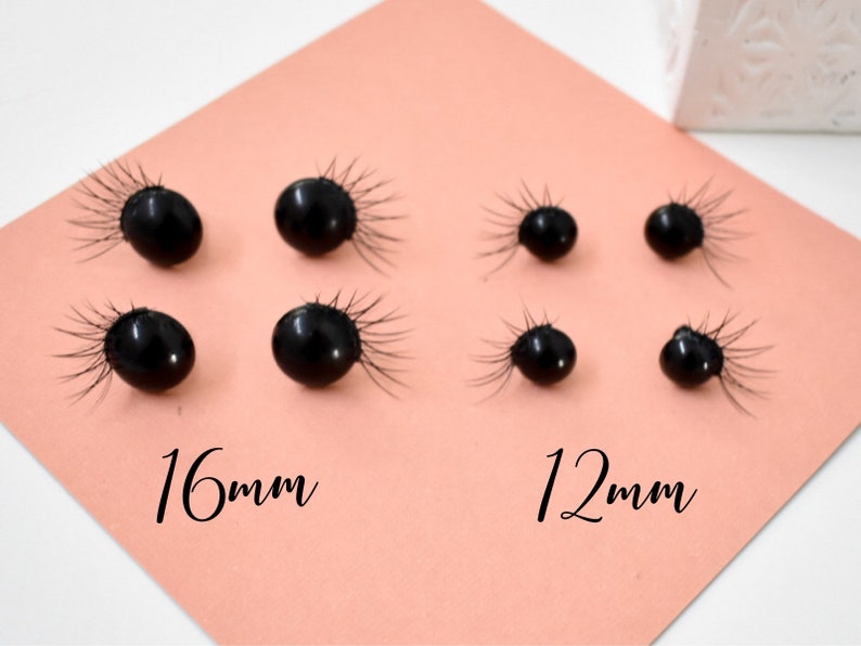 May include: Close-up of eight black round buttons with a fringe of black fibers around the edges. The buttons are arranged in two rows, with the top row labeled "16mm" and the bottom row labeled "12mm".