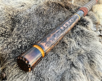 May include: A wooden staff with a dark brown finish and a yellow band. The staff is covered in intricate carvings and has a leather wrap at the top.