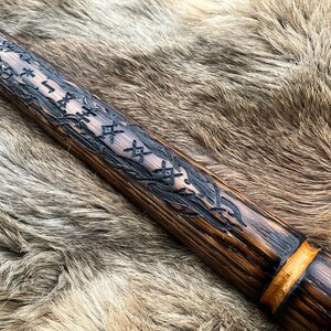 May include: A wooden staff with a dark brown finish and gold accents. The staff is decorated with intricate carvings of runes and vines.