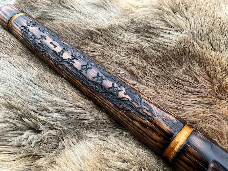May include: A wooden staff with a dark brown finish and gold accents. The staff is decorated with intricate carvings of runes and vines.