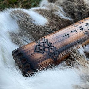 May include: A wooden staff with intricate carvings and runes. The staff is dark brown and has a smooth, polished finish. The runes are carved into the wood and are visible against the dark background.