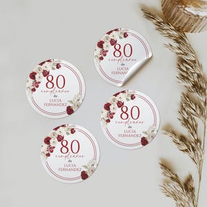 Puede incluir: Pegatinas redondas con la inscripción "80 cumpleaños de LUCIA FERNANDEZ" en escritura burdeos. Decoradas con detalles florales en burdeos y blanco.