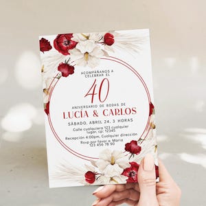 Puede incluir: Una tarjeta de invitación rectangular con fondo blanco, decorada con flores rojas y hierba de la pampa en acuarela. El texto dice: ACOMPAÑANOS A CELEBRAR EL 40 ANIVERSARIO DE BODAS DE LUCÍA & CARLOS, SÁBADO, ABRIL 24, 3 HORAS, Calle cualquiera 123.