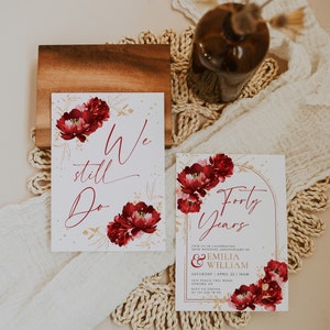 May include: Two wedding anniversary invitations with a floral design. The invitations are white with gold accents and red flowers. The text on the invitations reads "We still do" and "Forty Years".