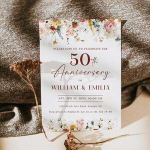 May include: A white invitation card with a floral design at the top and bottom. The text reads "Please join us to celebrate the 50th Anniversary of William & Emilia. Sat. Apr 22. 202X. 10:00 AM. 1234 Peach Tree Road. Sonoma AD. Rsvp please to Sophia by Apr 1st at 123 456-78-90."