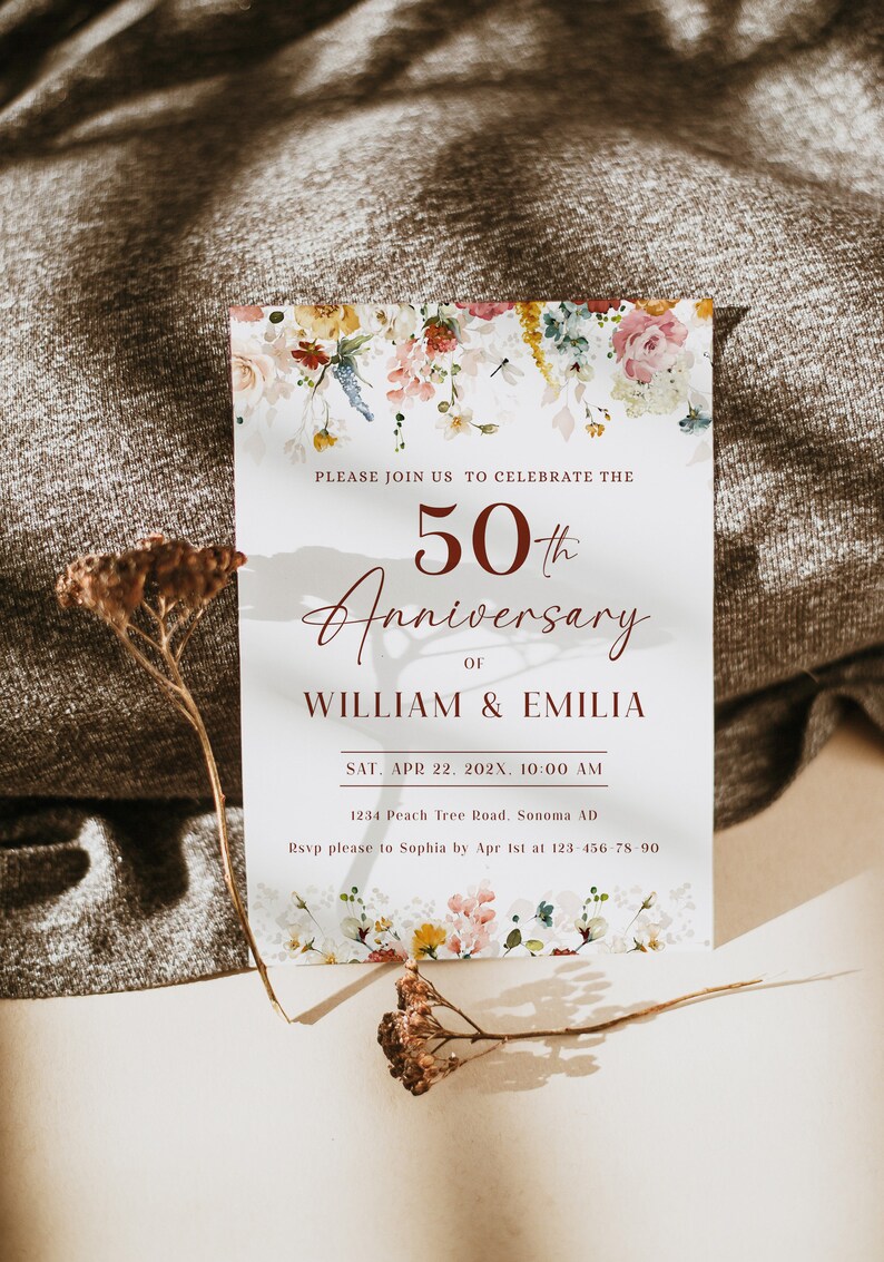 May include: A white invitation card with a floral design at the top and bottom. The text reads "Please join us to celebrate the 50th Anniversary of William & Emilia. Sat. Apr 22. 202X. 10:00 AM. 1234 Peach Tree Road. Sonoma AD. Rsvp please to Sophia by Apr 1st at 123 456-78-90."