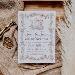 May include: A bridal shower invitation with floral accents and the text "Time for Tea." The invitation features a teapot and teacup illustration, with the bride's name, date, and time. The invitation is surrounded by pink and blue flowers.