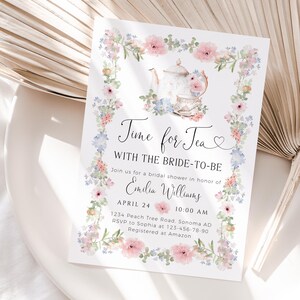 May include: A floral bridal shower invitation with the text "Time for Tea" and "With the Bride-to-Be." The invitation features a teapot and teacup illustration, surrounded by a floral border. The invitation includes the name "Emilia Williams" and event details.