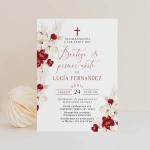 May include: A white invitation card with red floral accents and text in Spanish. The card announces a baptism and first birthday celebration for Lucía Fernández on April 24th at 10:00 AM. Includes contact information.